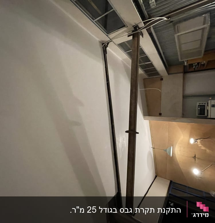 קיר גבס עם צינור מתכת ותאורה